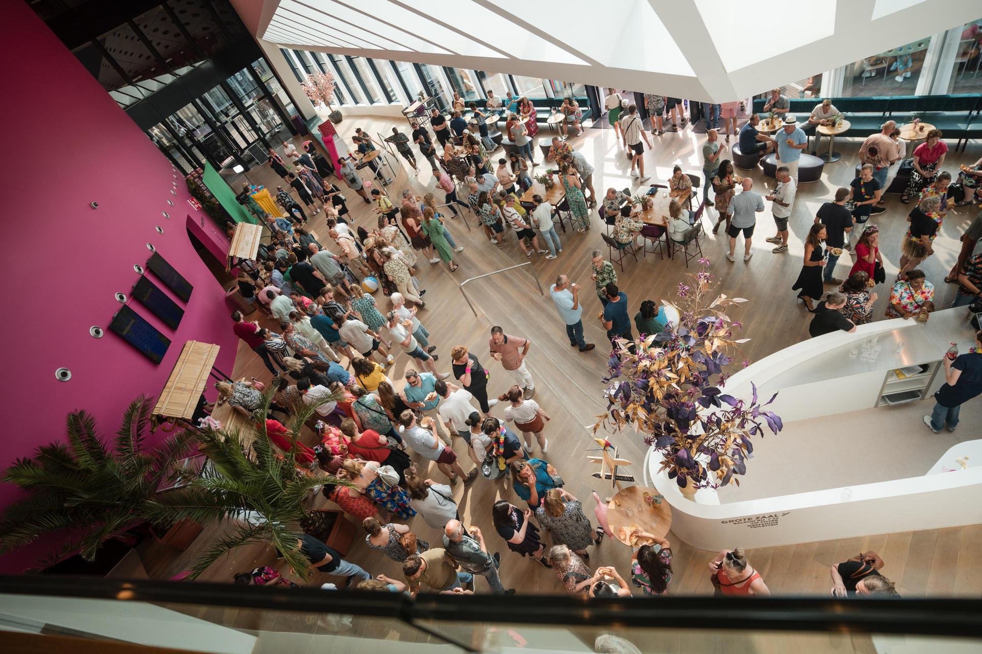 Foto van veel mensen in de foyer van Theater de Stoep gezien vanaf boven tijdens het Gemeentefeest
