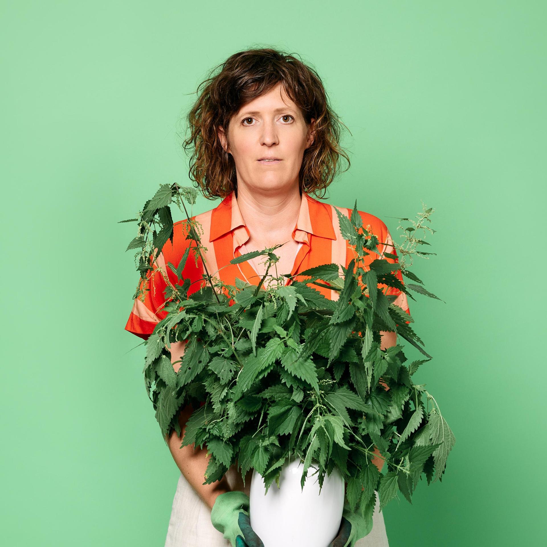 Janneke de Bijl, Promotiefoto van Janneke de Bijl met plan in haar handen tegen groene achterwand
