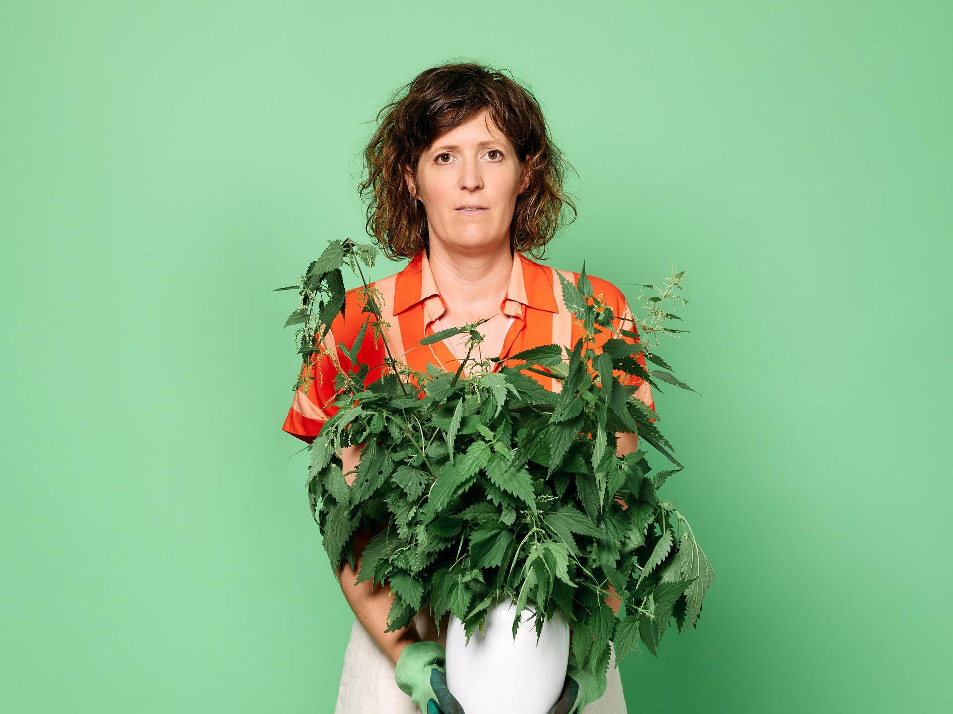 Janneke de Bijl, Promotiefoto van Janneke de Bijl met plan in haar handen tegen groene achterwand