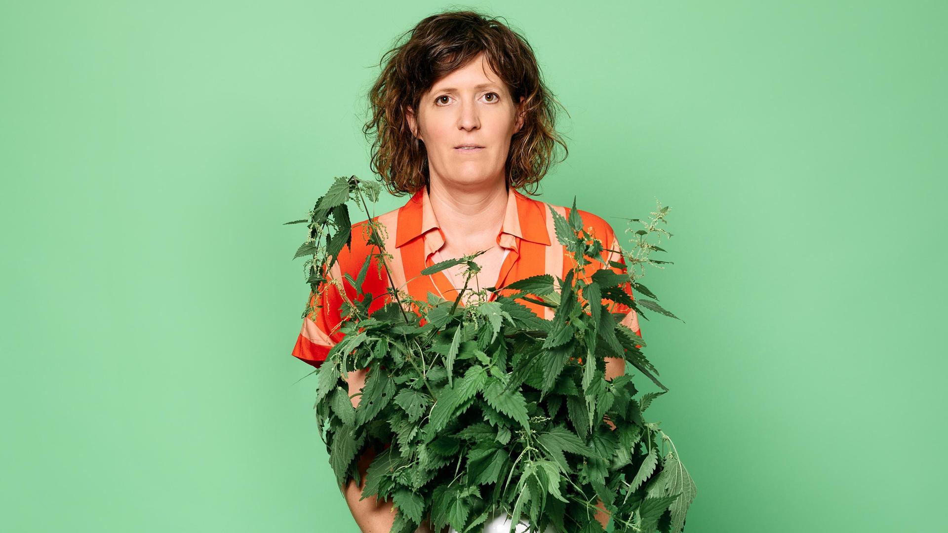 Janneke de Bijl, Promotiefoto van Janneke de Bijl met plan in haar handen tegen groene achterwand