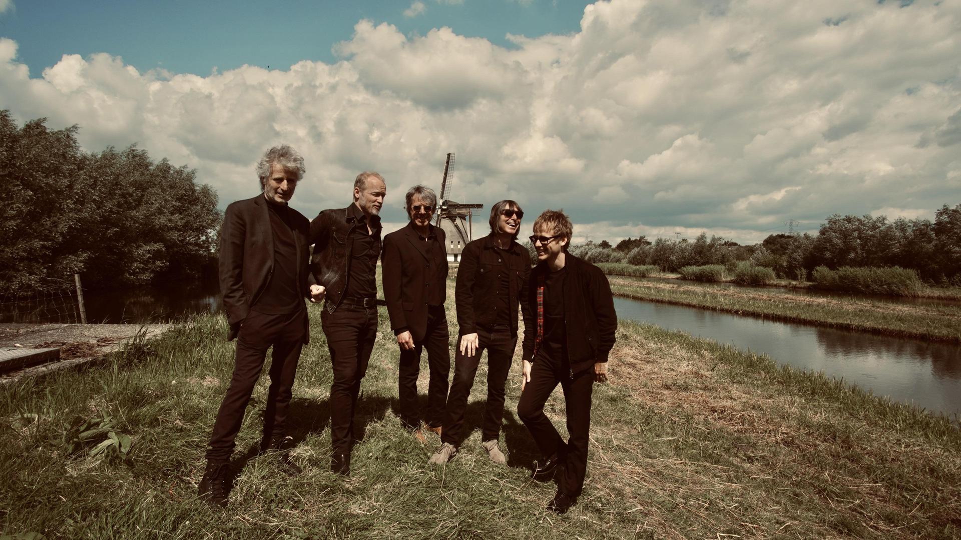 Timebox, Promotiefoto van de band Timebox op een veld met wolkenlucht erboven
