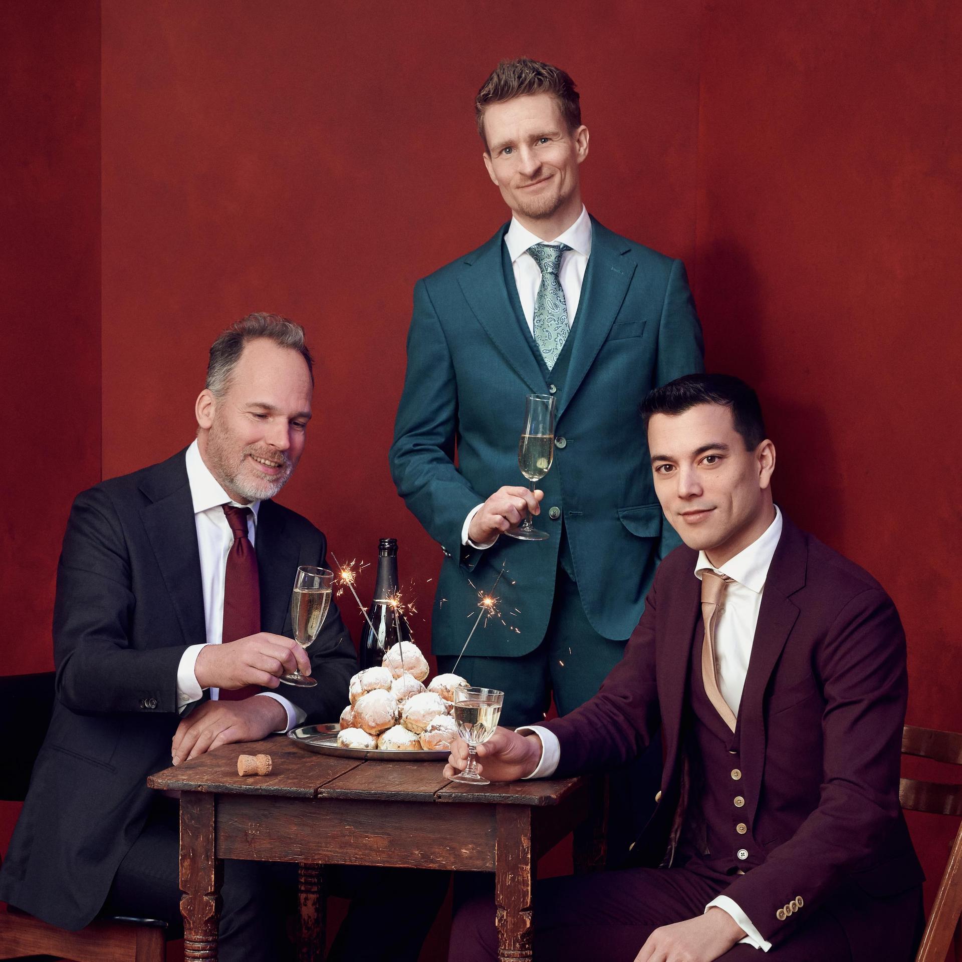 Andries Tunru & Stefan Hendrikx, Promotiefoto met Andries Tunru, Stefan Hendrikx en nog een man tegen een rode achtergrond