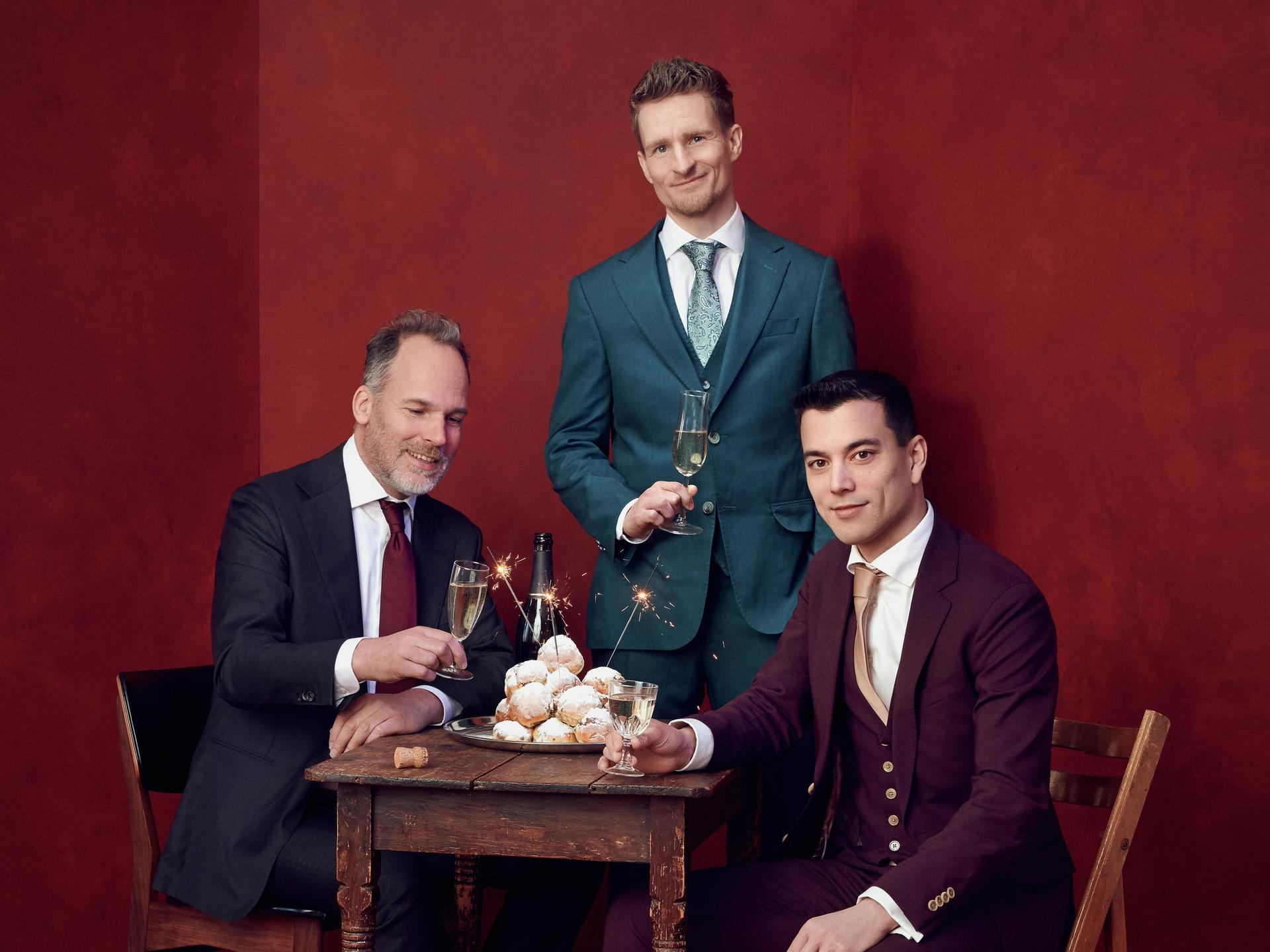 Andries Tunru & Stefan Hendrikx, Promotiefoto met Andries Tunru, Stefan Hendrikx en nog een man tegen een rode achtergrond