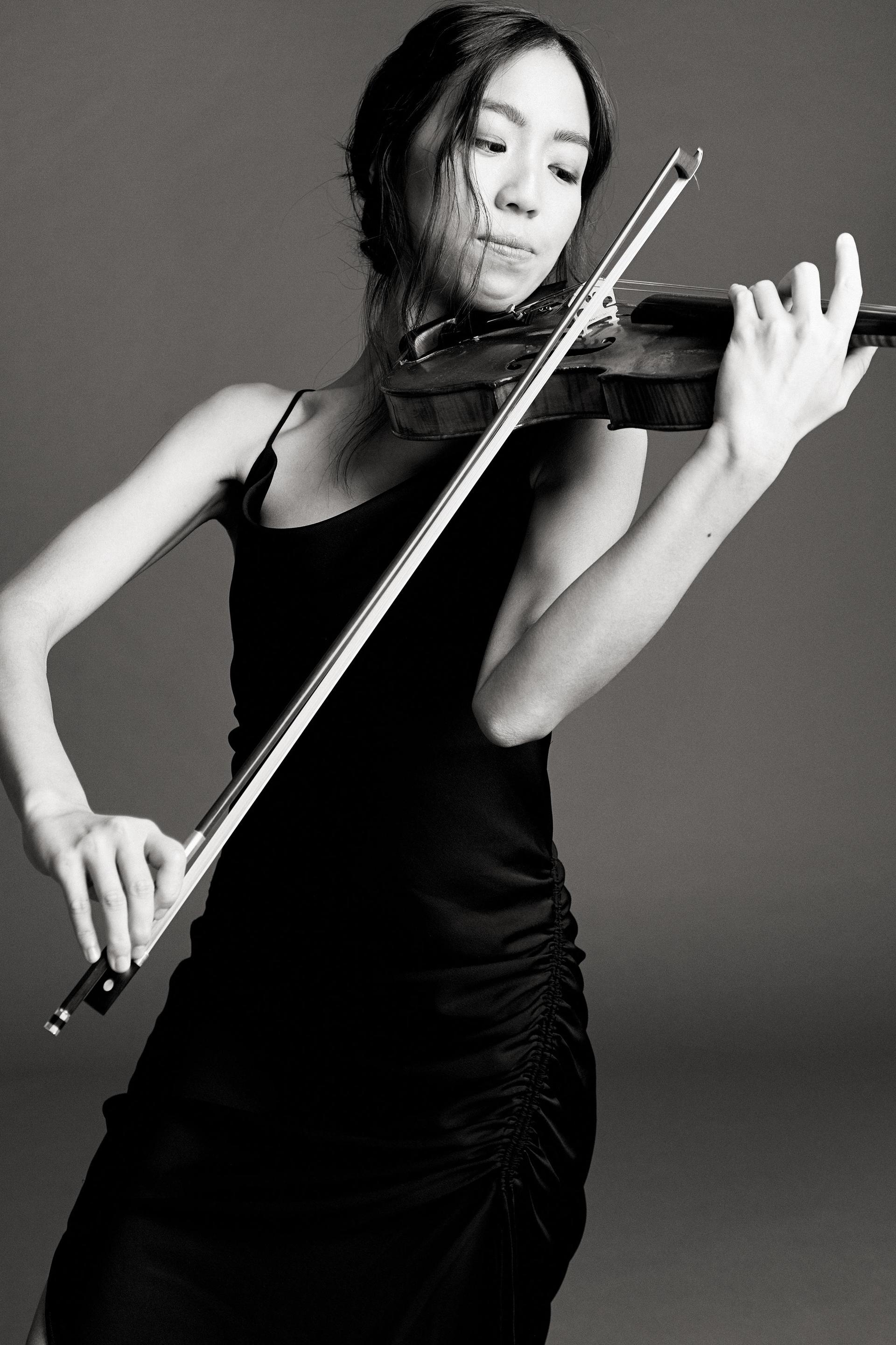 Promotiefoto van Shannon Lee in zwart wit terwijl ze op de viool speelt