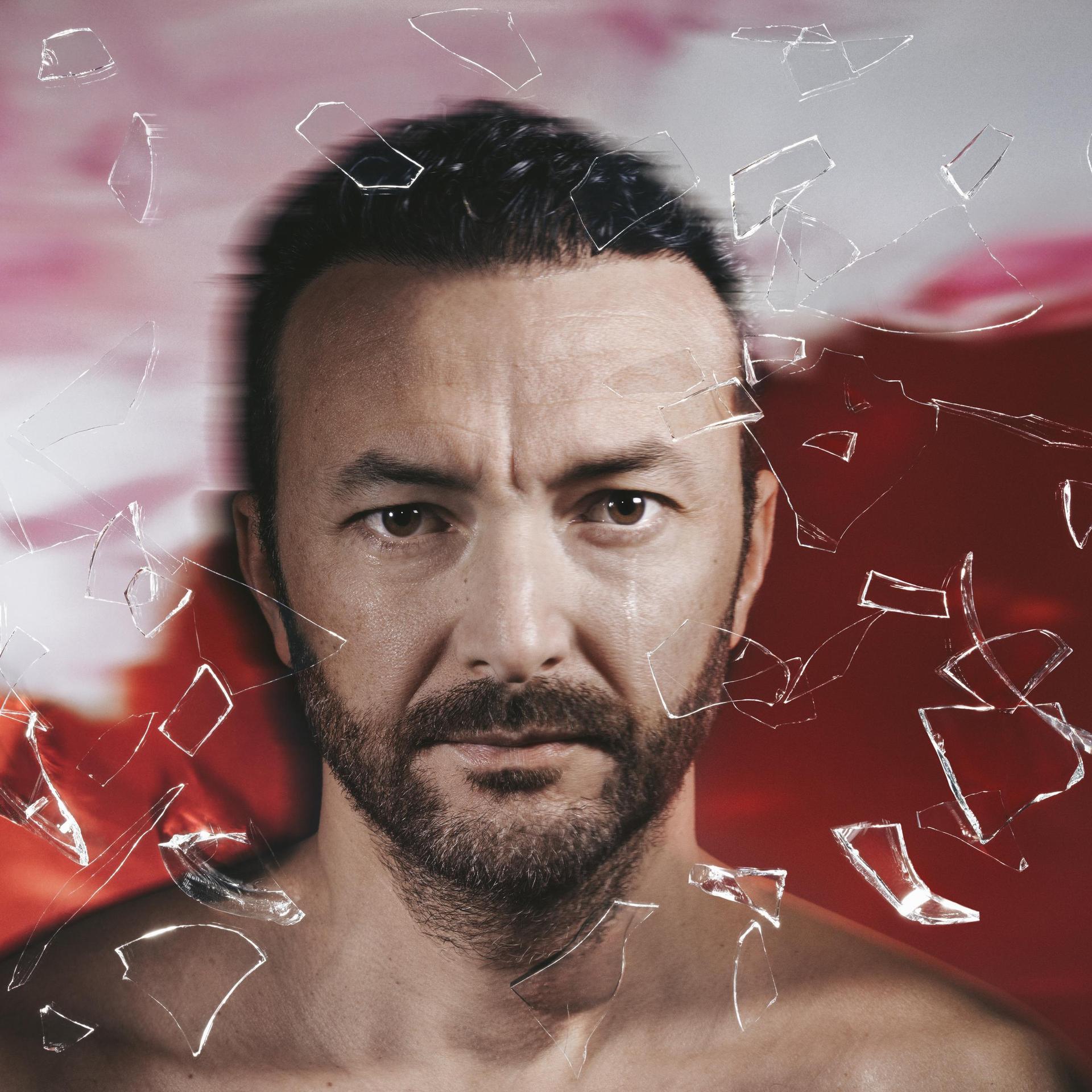 Nasrdin Dchar, Promotiefoto van Nasrdin Dchar voor een rode achtergrond met glasscherven om hem heen