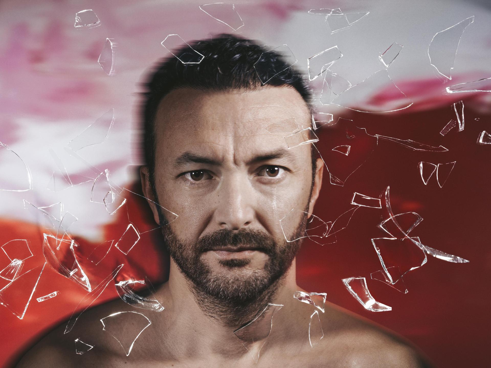 Nasrdin Dchar, Promotiefoto van Nasrdin Dchar voor een rode achtergrond met glasscherven om hem heen