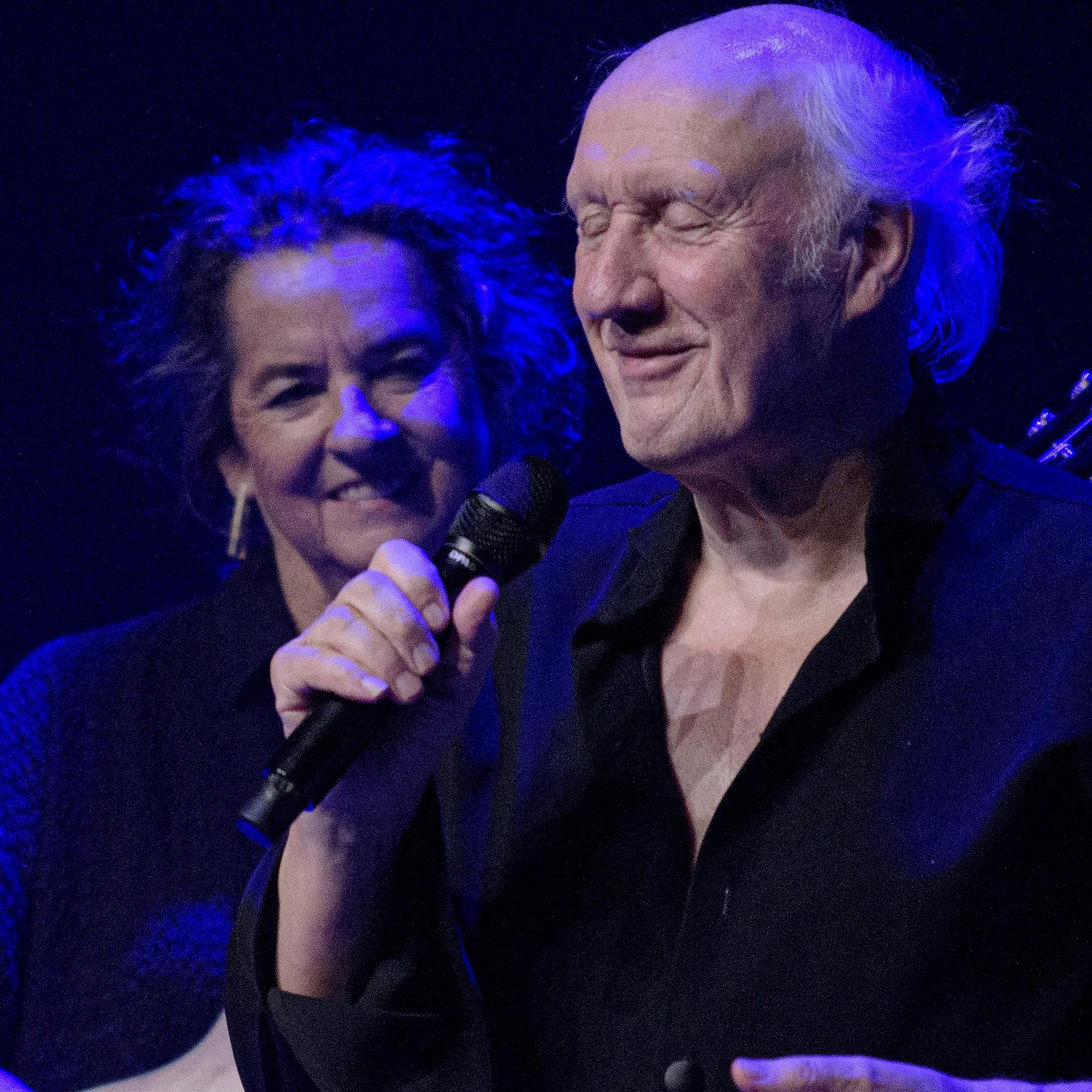 Herman van Veen, Promotiefoto van Herman van Veen met microfoon en gitarist achter hem
