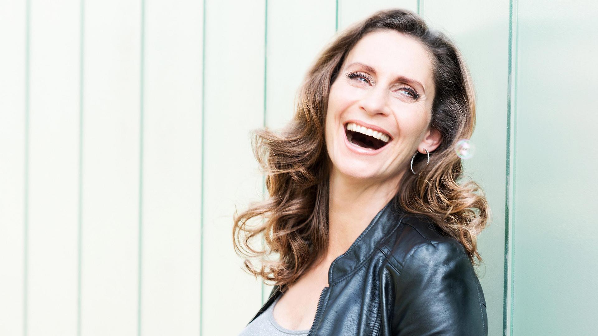 Pia!, Promotiefoto van Pia Douwes lachend tegen een lichtgroene achtergrond