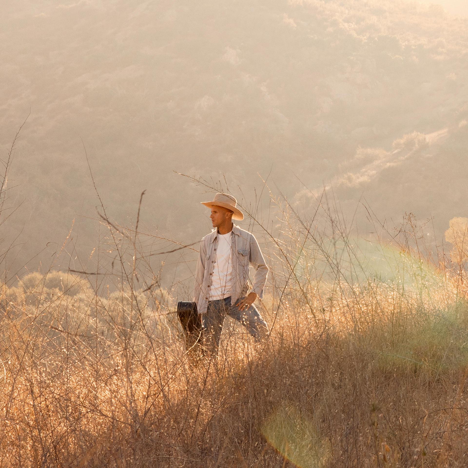 Milow, Promotiefoto van Milow op een berg met een diepte achter zich en in het zonnetje