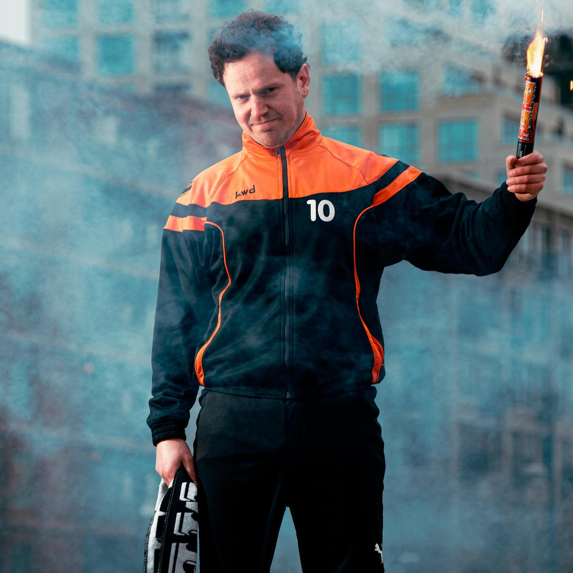 Jules Keeris, Promotiefoto van Jules Keeris met een fakkel in zijn hand op een groene grastegel midden in een stad