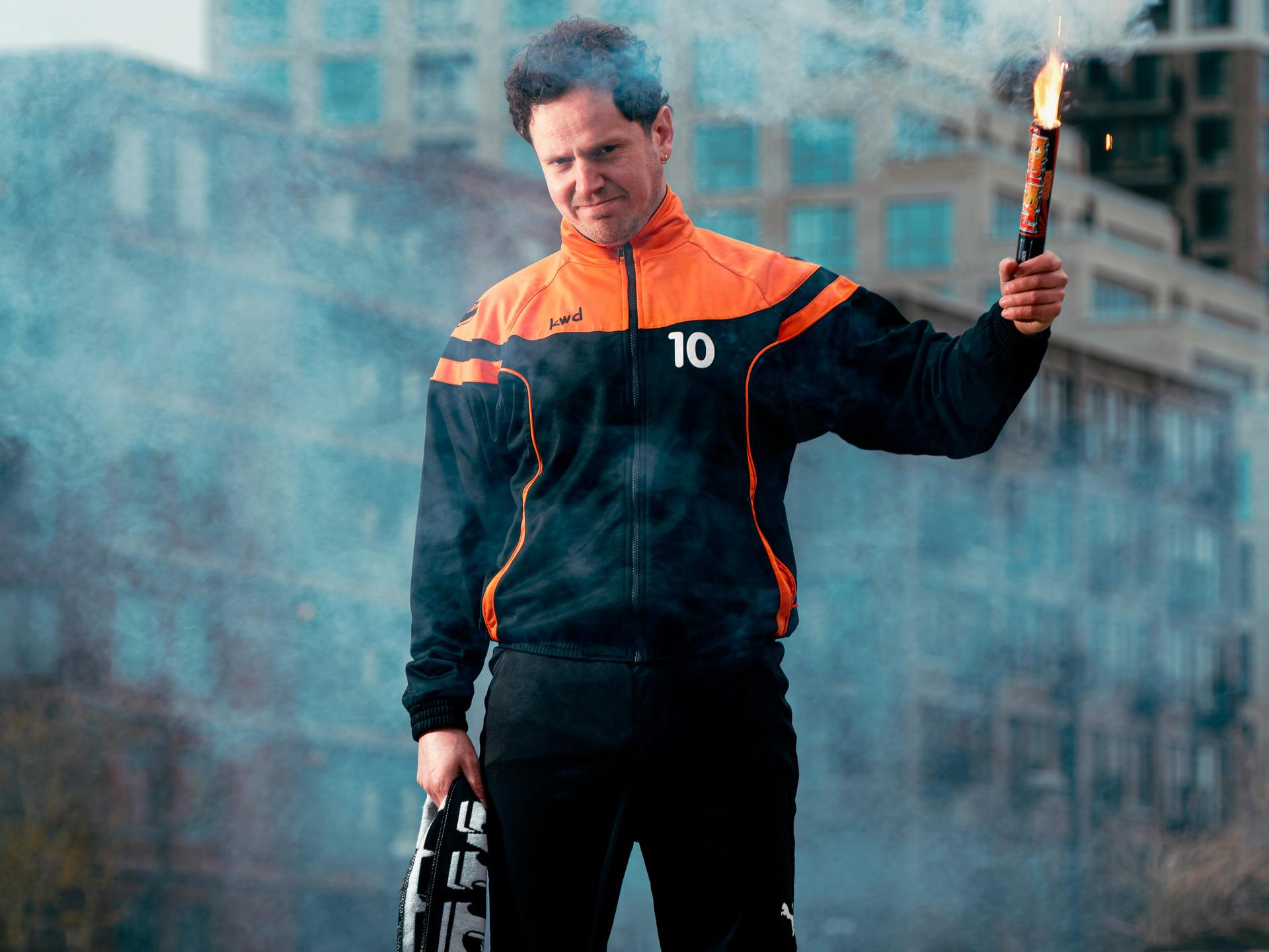 Jules Keeris, Promotiefoto van Jules Keeris met een fakkel in zijn hand op een groene grastegel midden in een stad