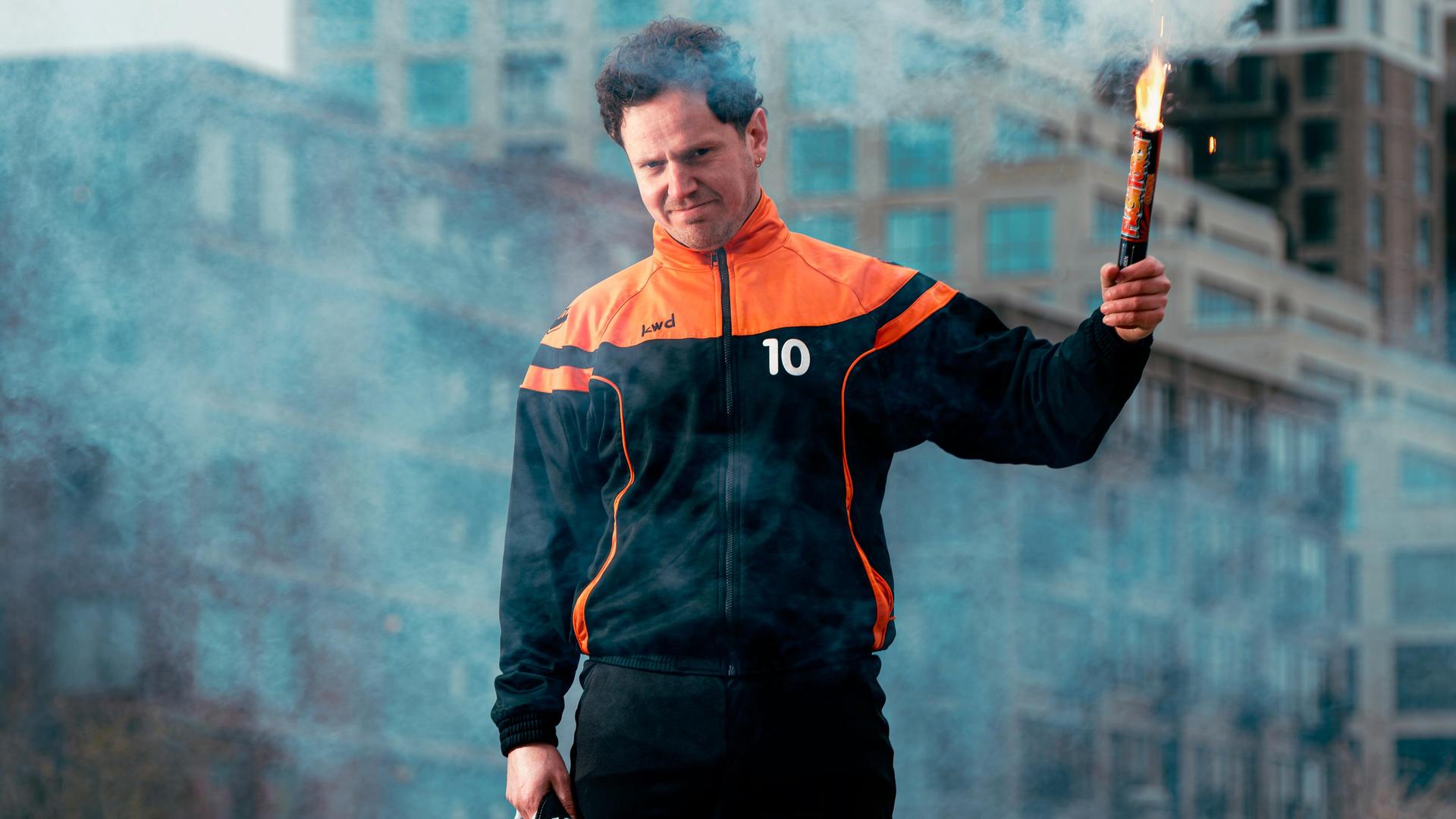 Jules Keeris, Promotiefoto van Jules Keeris met een fakkel in zijn hand op een groene grastegel midden in een stad