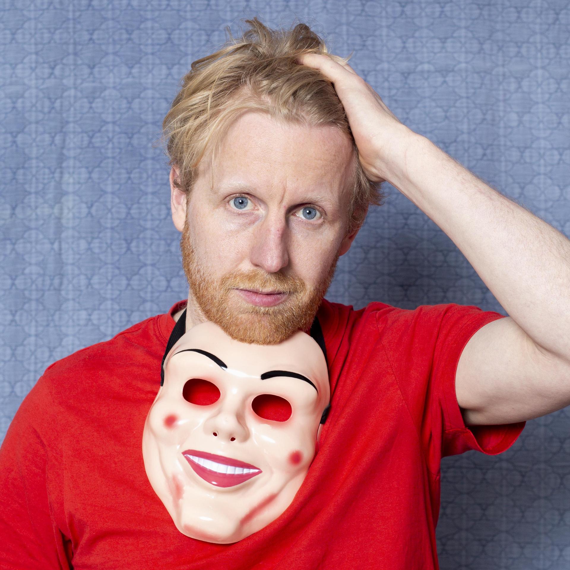 Piet van Eeghen, Promotiefoto van Piet van Eeghen met rood shirt aan, hand in zijn haar en masker om zijn nek