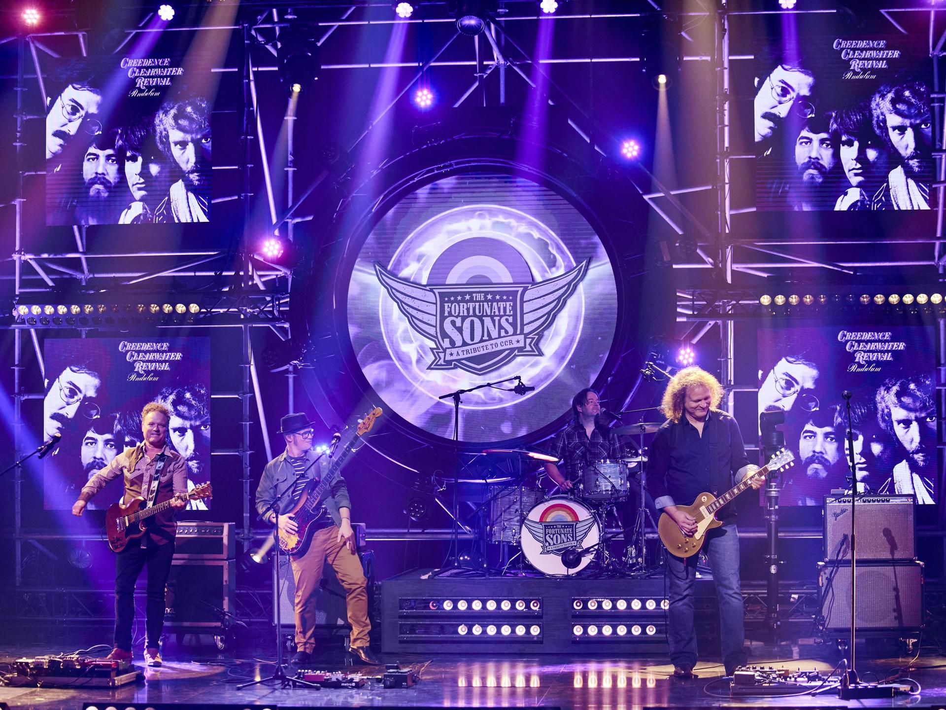 The Fortunate Sons, Promotiefoto van The Fortunate Sons - de band op het podium met paarse achtergrond