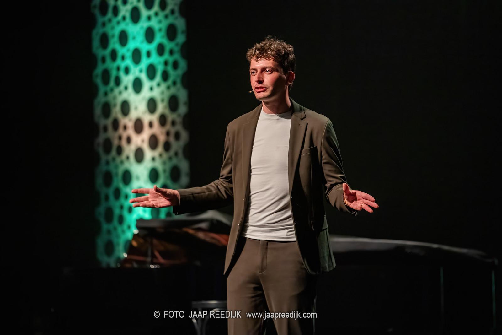 Foto van Tijmen Dokter op het podium tijdens de presentatie avond