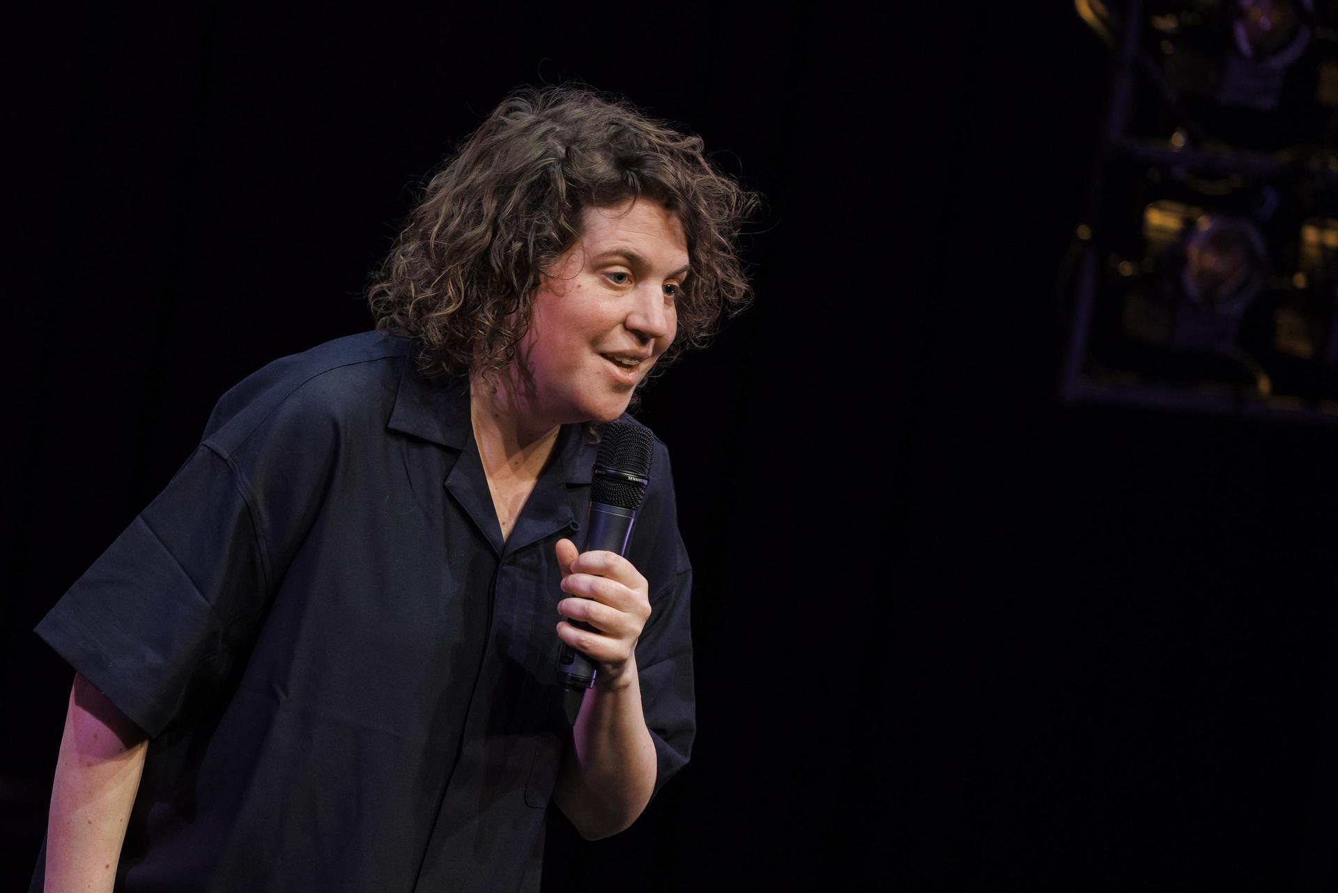 scènefoto's van Kim Schuddeboom op het podium met microfoon