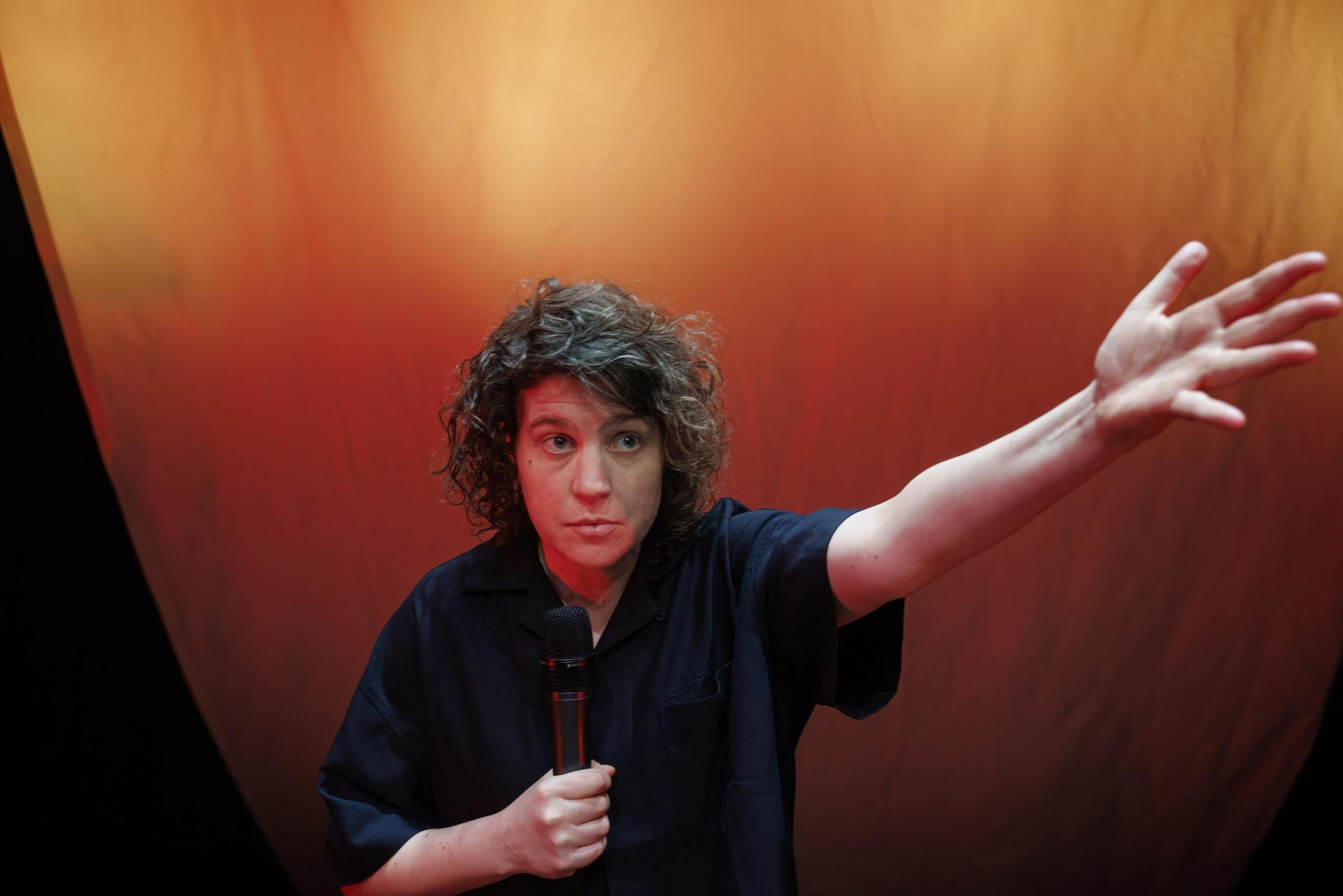 scènefoto's van Kim Schuddeboom op het podium met microfoon