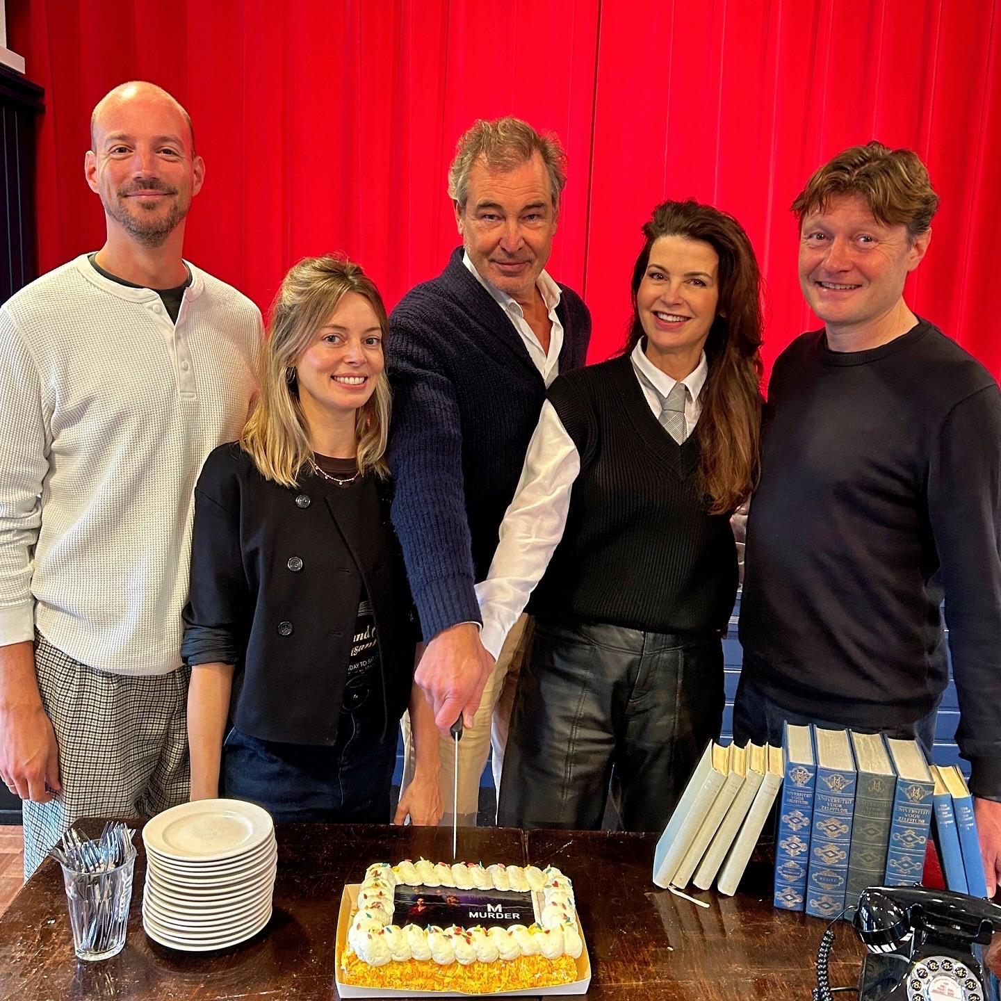 Foto met de cast van Dial M die de taart aansnijdt