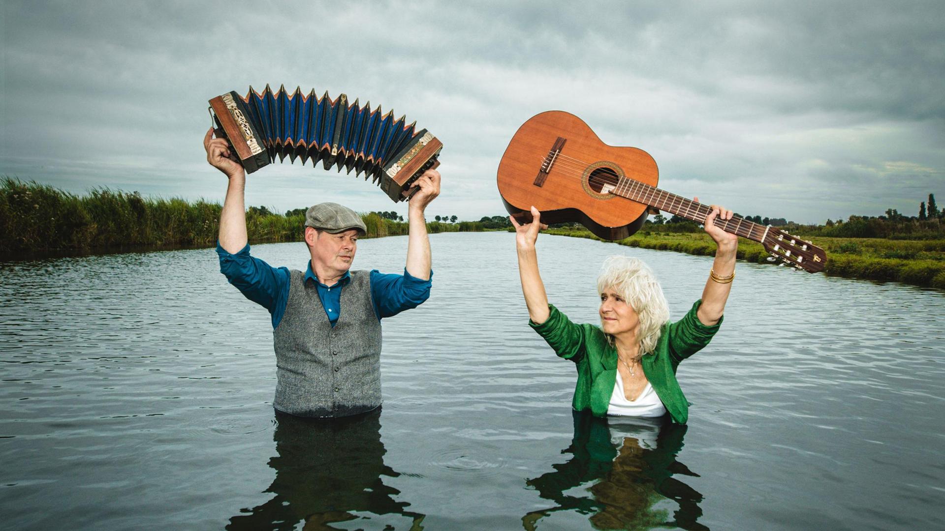 Leoni Jansen en Carel Kraayenhof, Promotiebeeld Leonie Jansen en Carel Kraayenhof, staand in het water met instrument boven hun hoofd
