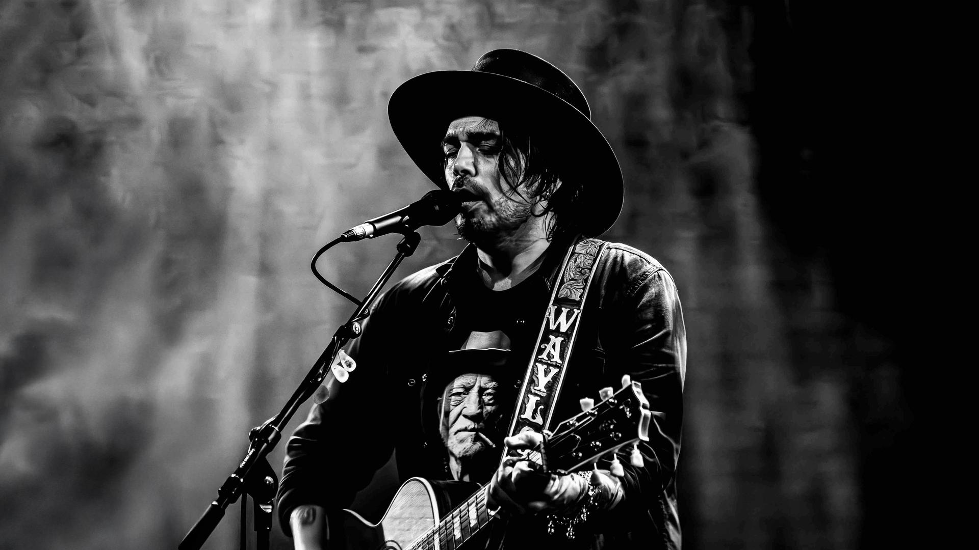 Waylon, Promotiefoto van Waylon in zwart wit met cowboy hoed op en gitaar achter de microfoon