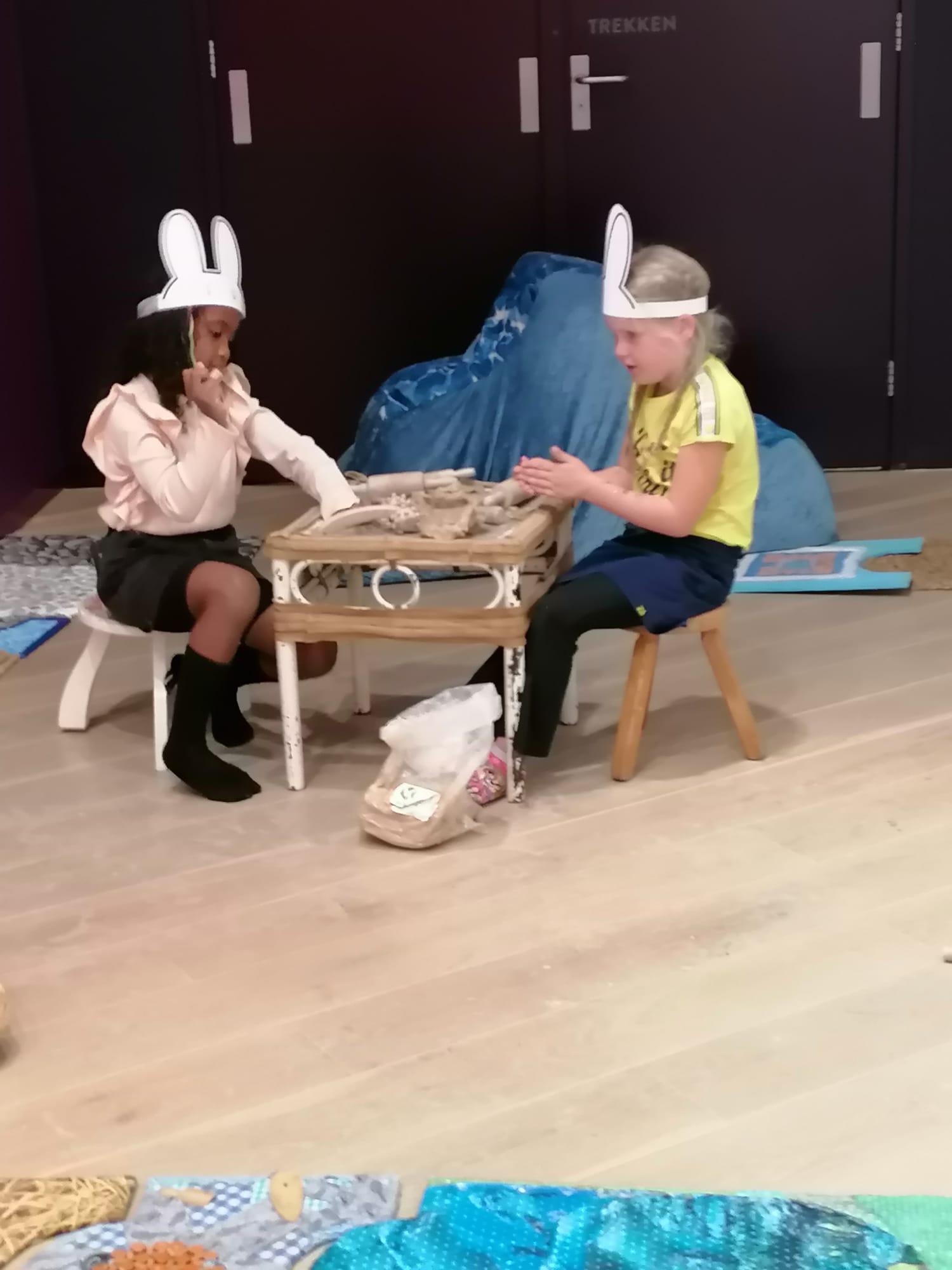 Foto van twee spelende meisjes aan een tafeltje in de foyer van Theater de Stoep