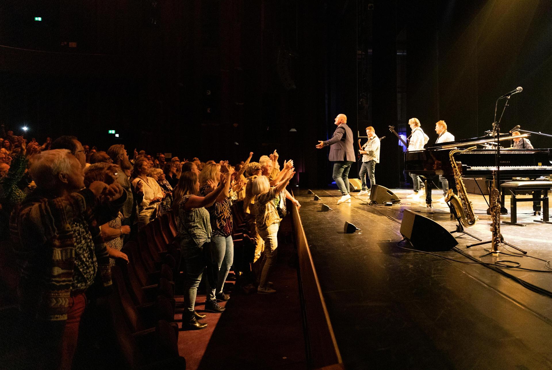 scènefoto van een optreden op het podium van de Grote Zaal van de zijkant gezien.