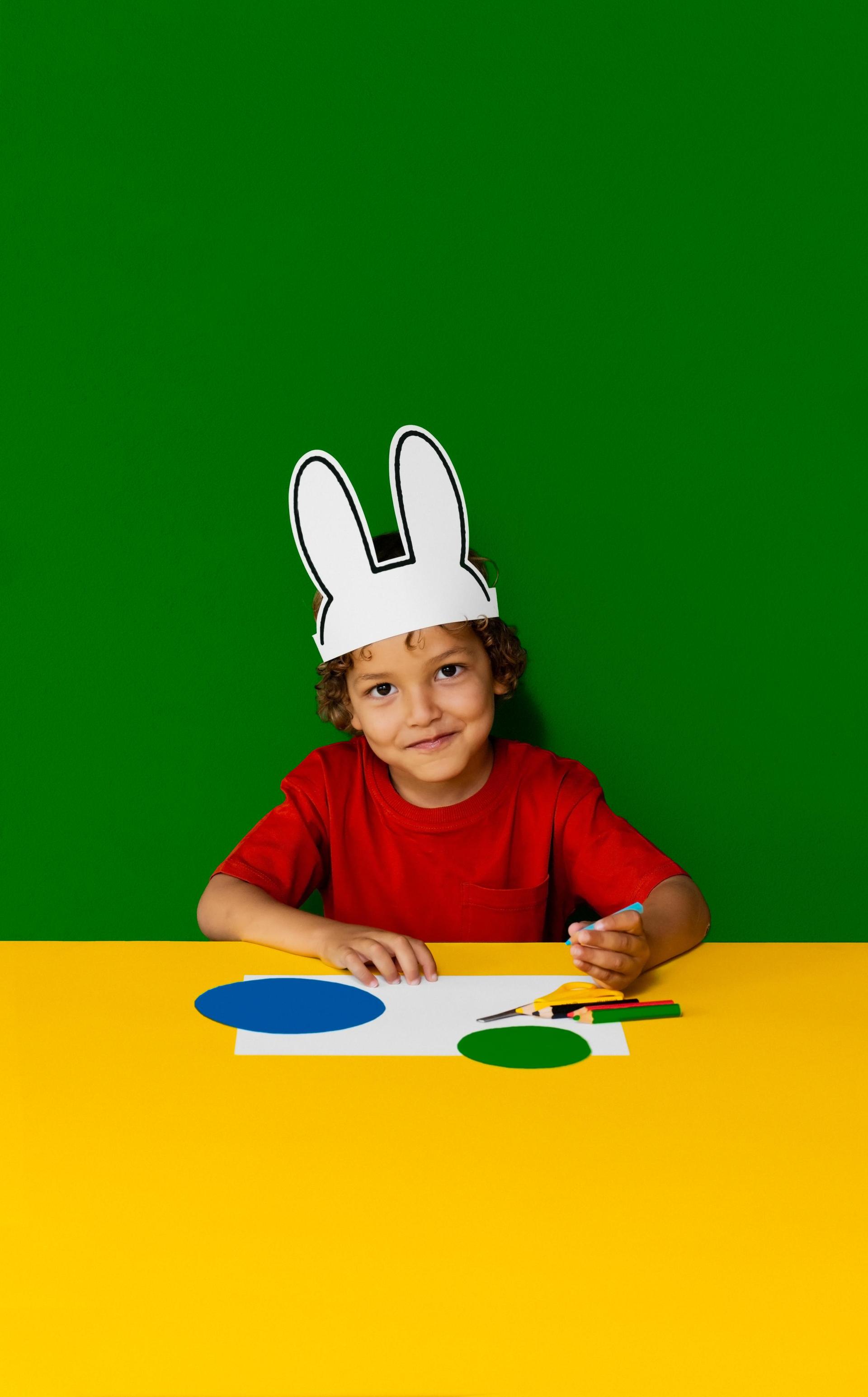 Foto van jongetje met nijntje oren die aan het kleuren is