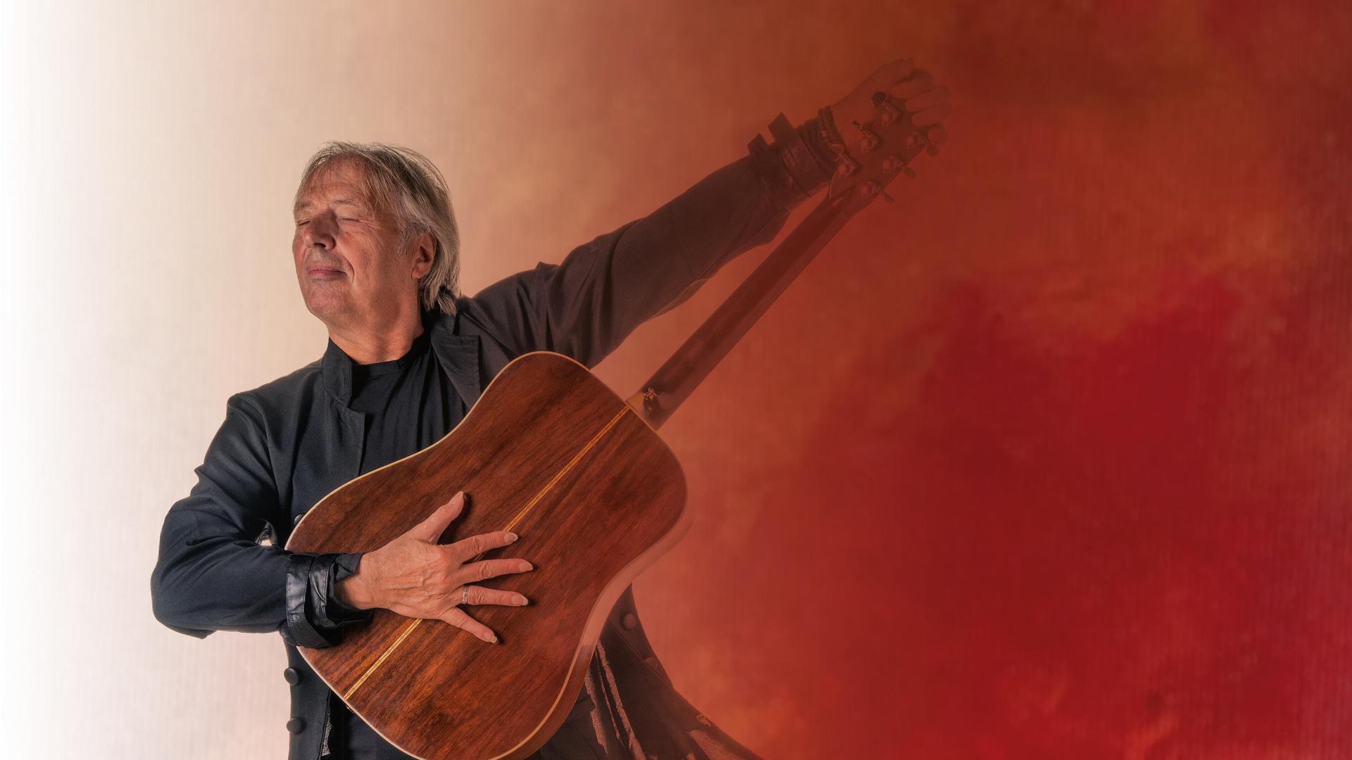 Harry Sacksioni, promotiefoto Harry Sacksioni met houten gitaar die hij omhoog houdt