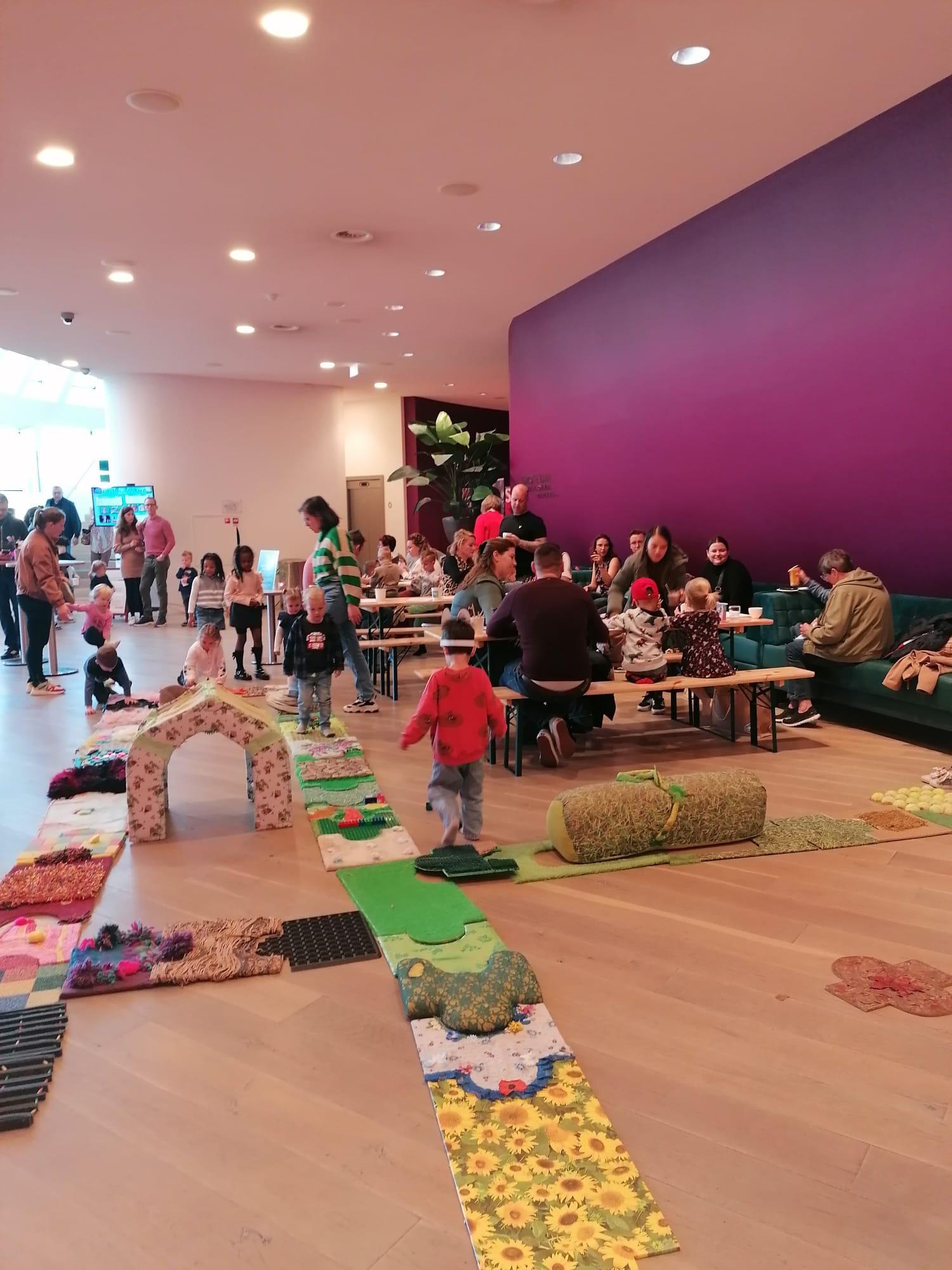 Foto van de eerste Stoep Kids Dag met spelende kindjes in de foyer van theater de Stoep