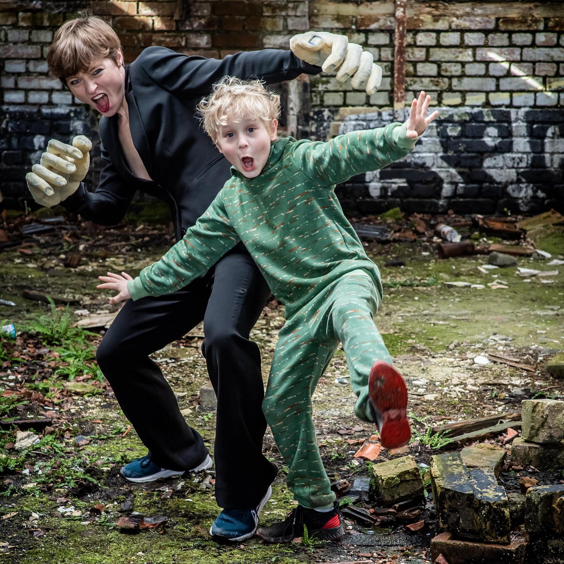 Het Geweldige Grote Mensen Stuk (8+), Foto Geweldige Grote Mensen Stuk. Foto van jongetje en vrouw schoppend richting de camera