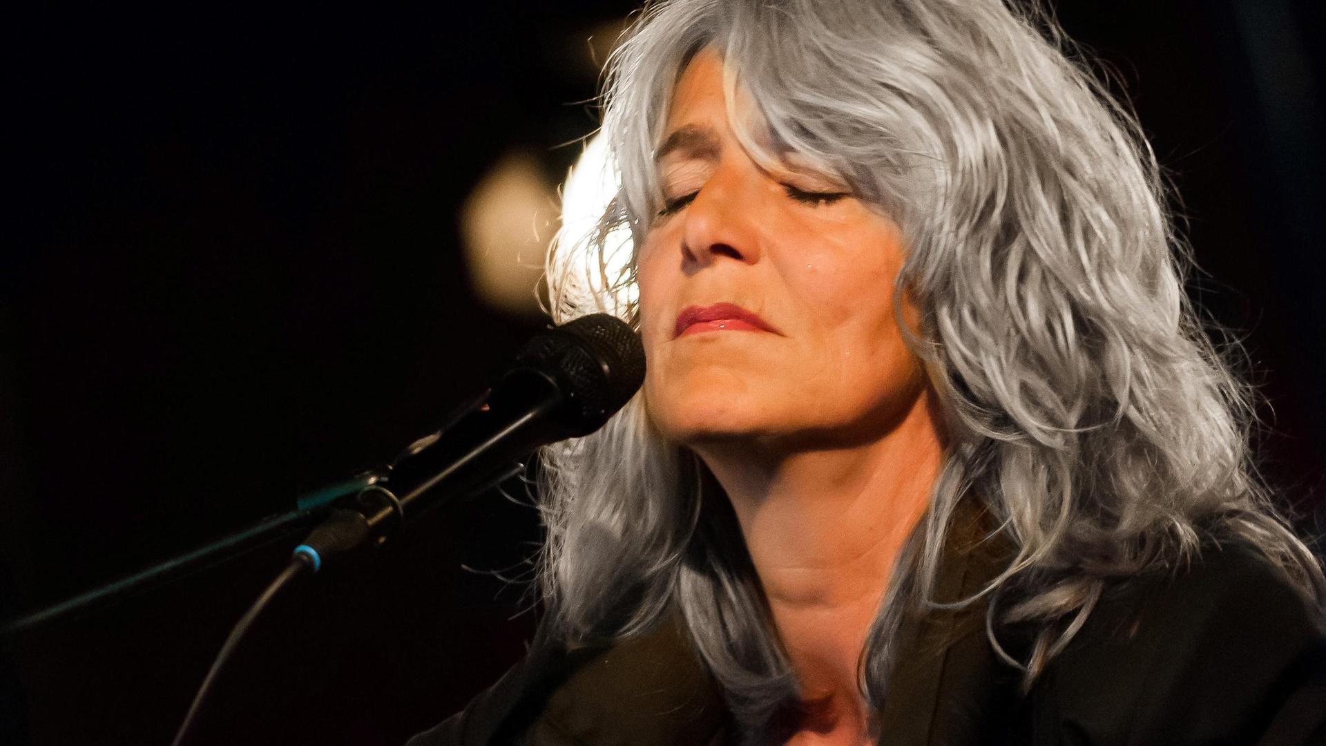 Leoni Jansen, Foto van Leoni Jansen op gitaar voor de microfoon