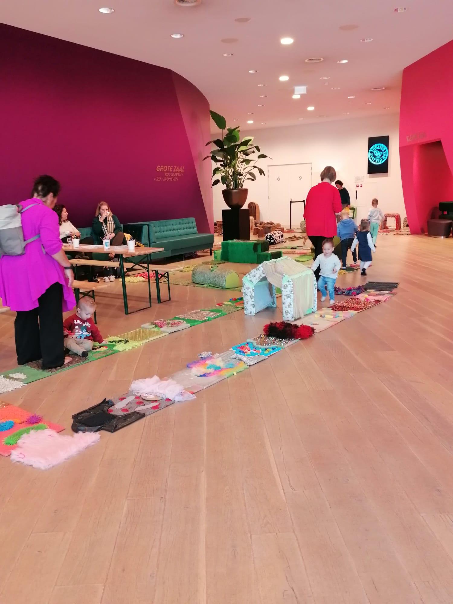 Foto van de eerste Stoep Kids Dag met spelende kindjes in de foyer van Theater de Stoep