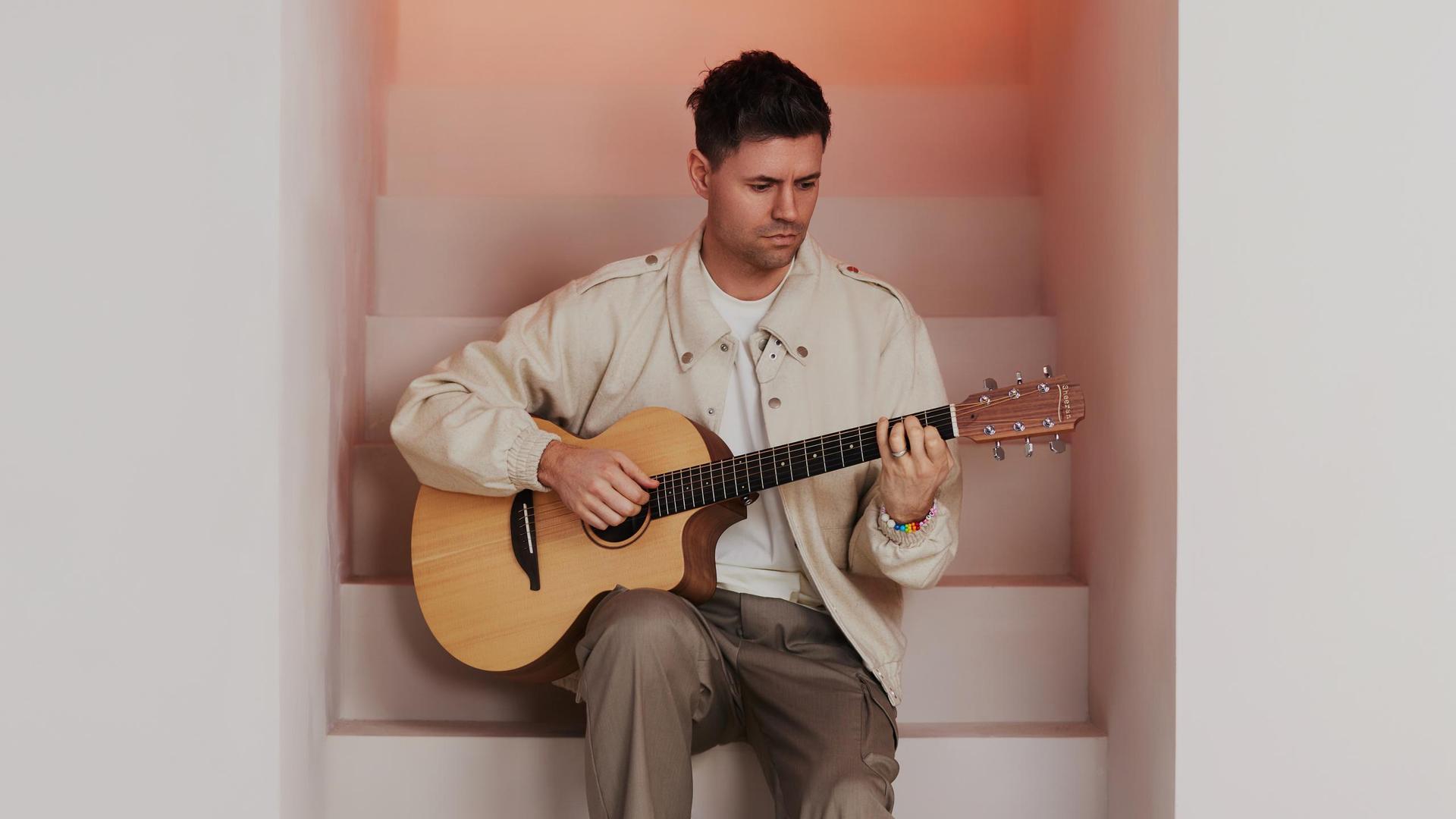 Simon Keizer, Foto Simon Keizer zittend op witte trap met gitaar in zijn handen