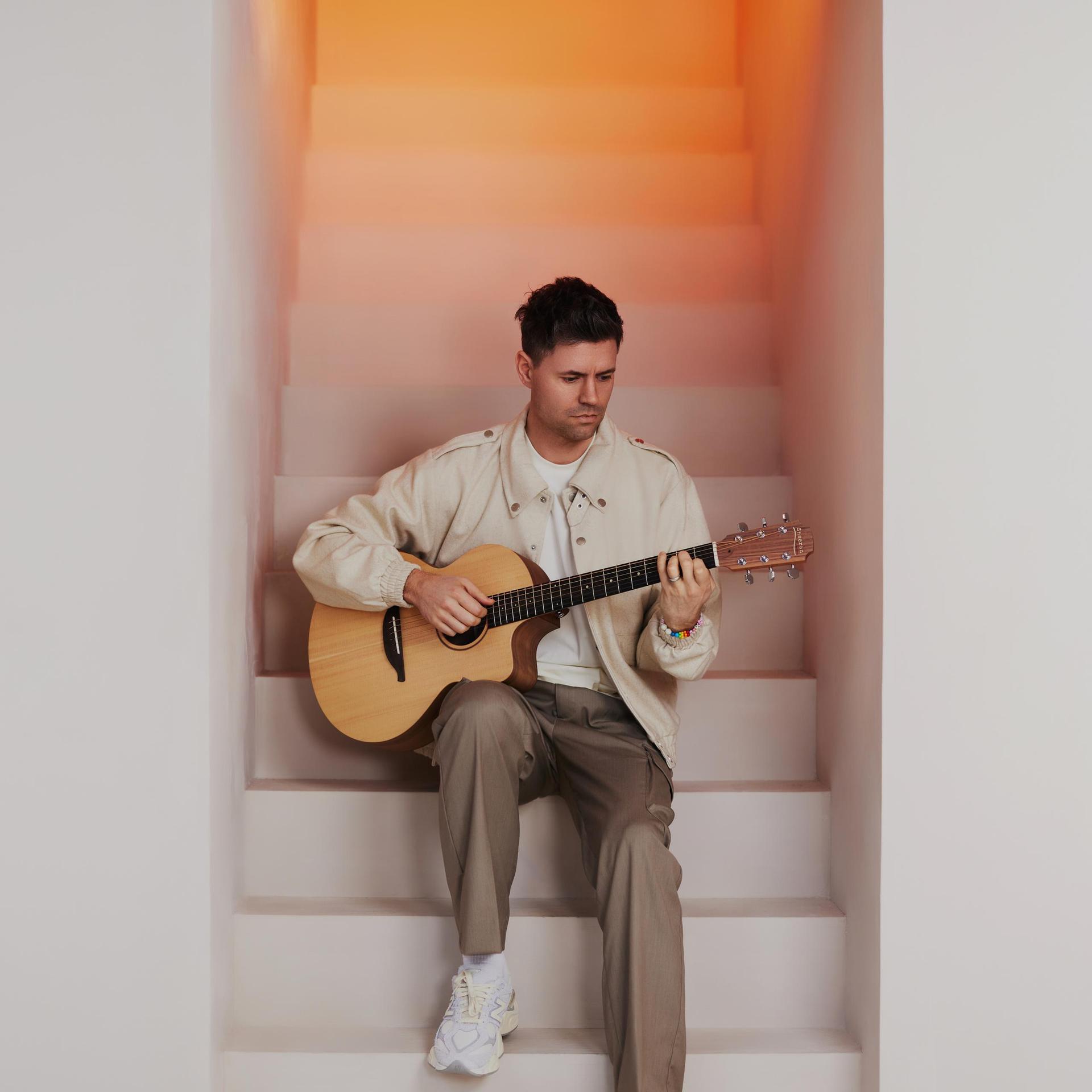 Simon Keizer, Foto Simon Keizer zittend op witte trap met gitaar in zijn handen