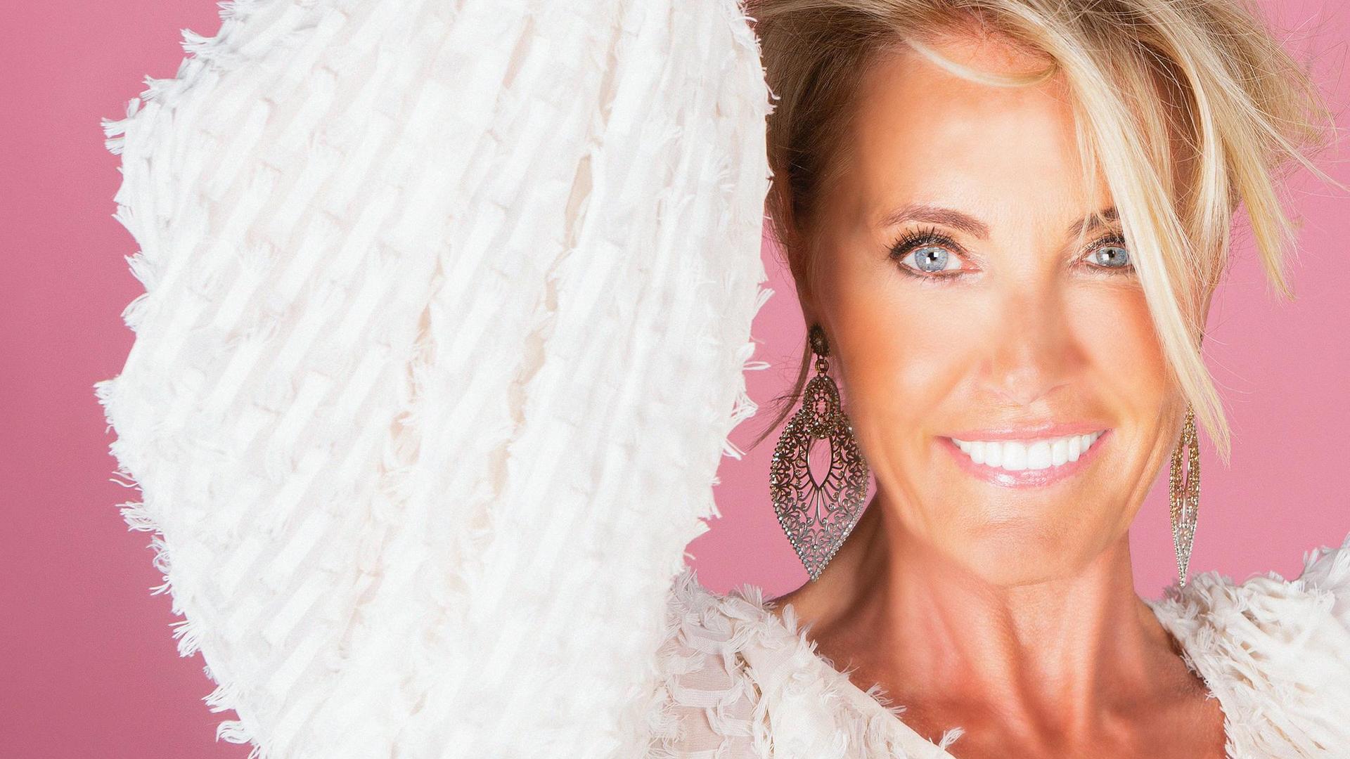 Dana Winner, Promotiefoto van Dana Winner met witte blouse aan tegen roze achtergrond