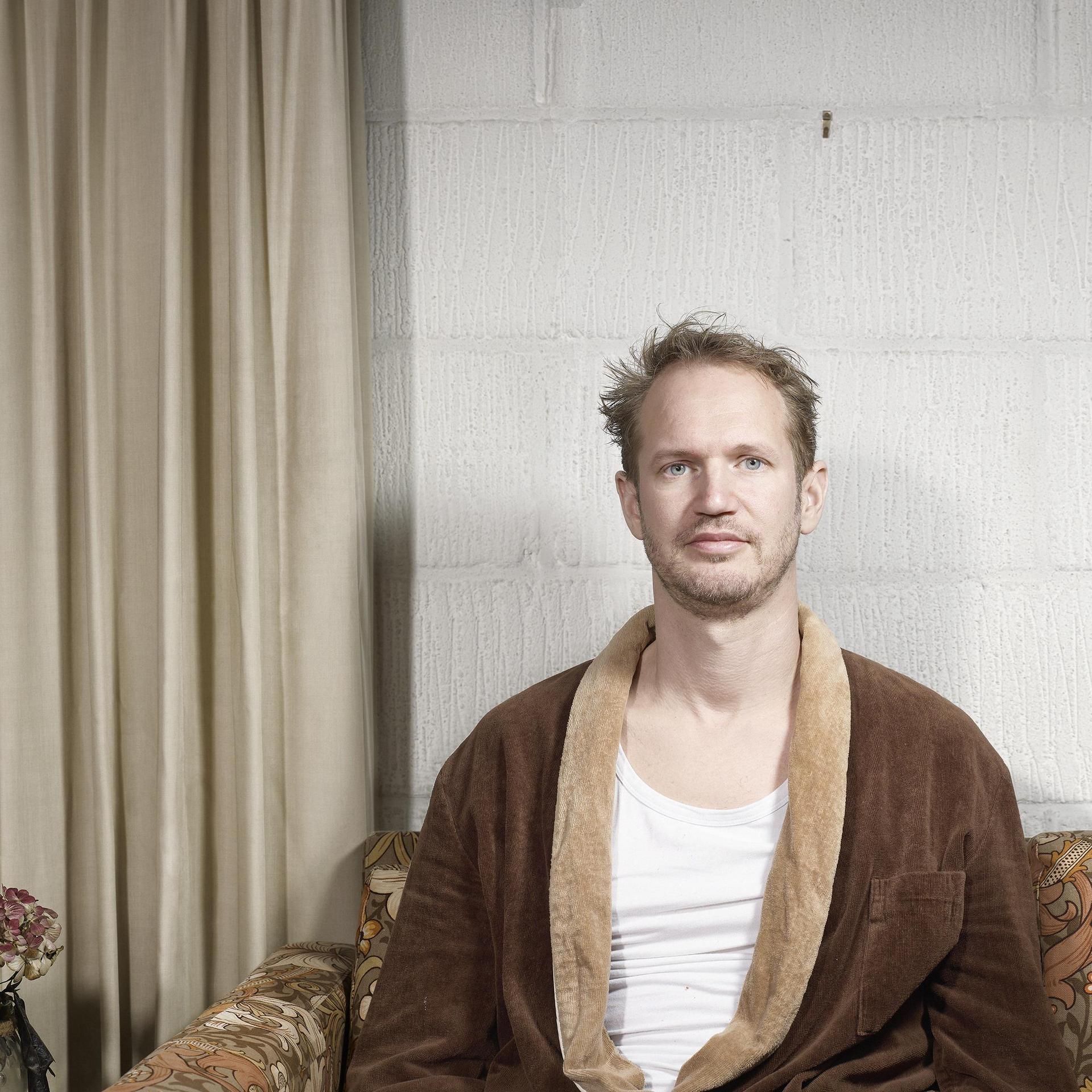 Johan Goossens, Promotiefoto van Johan Goossens met wit hemd en bruine ochtendjas aan