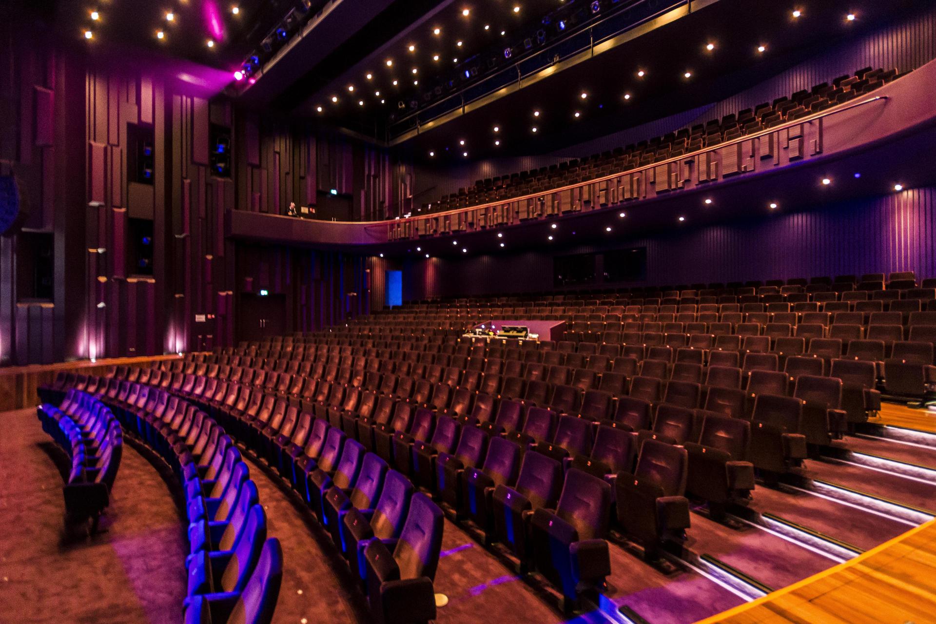 Foto van de stoelen in de Grote Zaal mooi belicht in paars/blauwe tinten