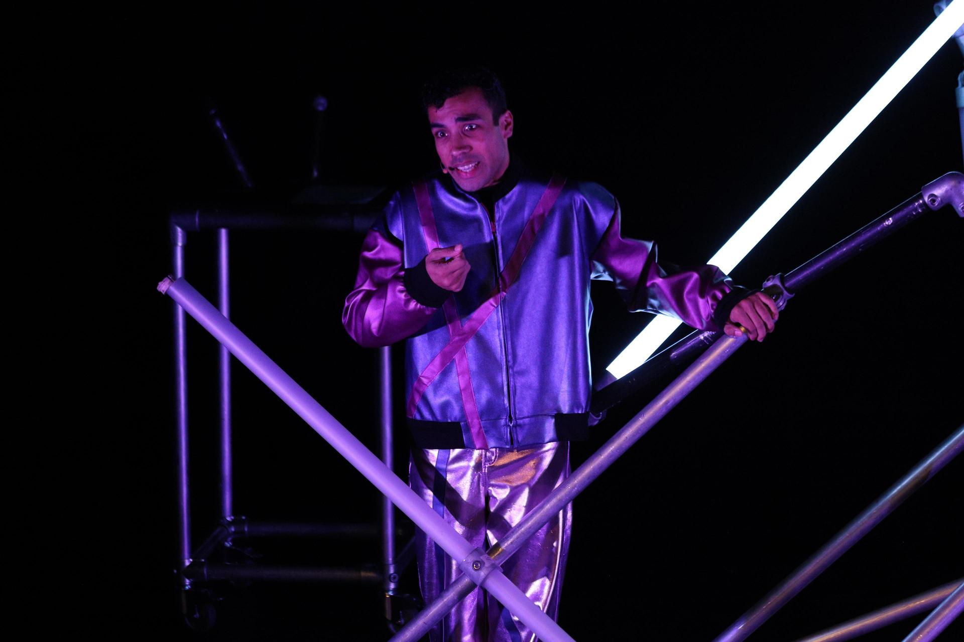 Aron Elstek op het podium staand in de stellage.