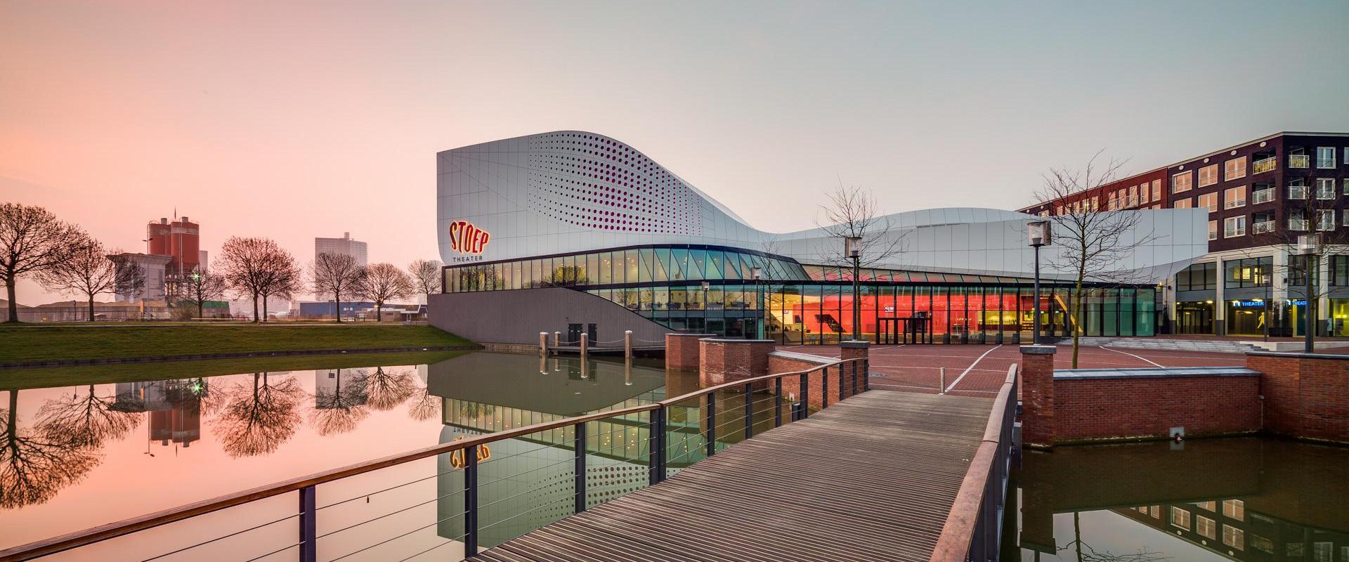 Bereikbaarheid, Foto van buitenzijde Theater de Stoep gezien vanaf de brug over de vijver in schemering