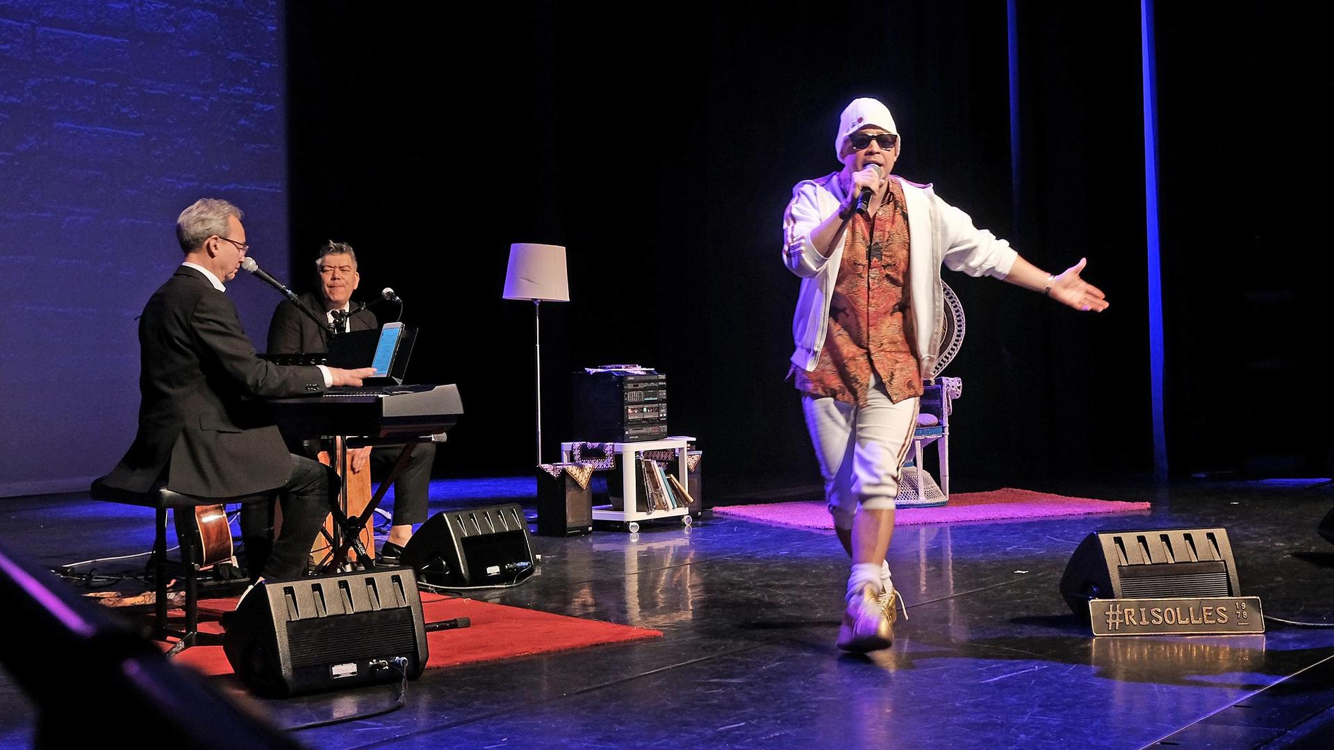 Ricky Risolles, scènefoto Ricky Risolles in wit pak met witte muts en zonnebril op